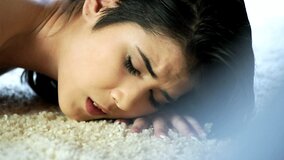 A solo girl brunette is resting on her ass, playing with her cunt