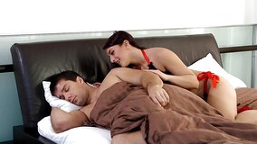 A redhead and a blonde are fucking a dude on the bed in a threesome